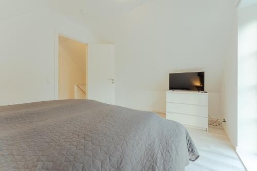 a bedroom with a bed and a flat screen tv at New Boat House in Leirvík