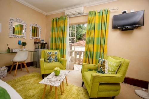 a living room with two chairs and a tv at TDM's Boutique Guest House in Pretoria