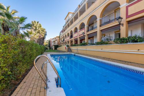 uma piscina em frente a um edifício em La Quinta II by Ĥ na Isla Canela