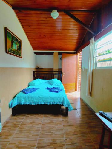 Quarto Maringá Minas في بوكاينا دي ميناس: غرفة نوم بسرير وسقف خشبي