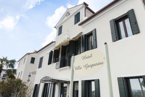 ドーロにあるビラ ガスパリーニの白い建物で、グローバルなラグジュアリーアパートメントを読む看板が付いています。