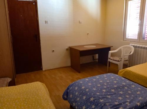 a bedroom with a desk and a bed and a table at Villa Natalija in Podgorica