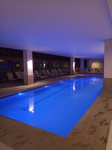 uma piscina com iluminação azul num hotel em Flat Pedra Azul em Aracê