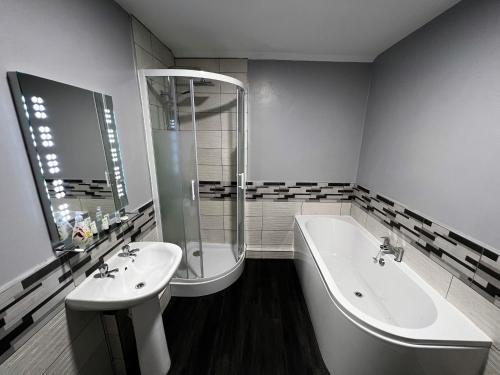La salle de bains est pourvue d'une baignoire, d'un lavabo et d'une baignoire. dans l'établissement Kema Cottage, à East Cowes