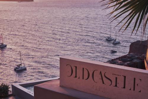 a sign that reads docked boats in the water at Old Castle Oia in Oia