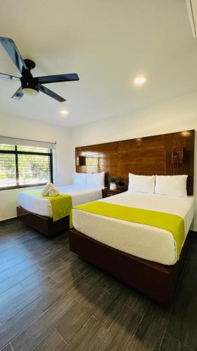 a bedroom with two beds and a ceiling fan at Mayan Water Hotel in Playa del Carmen