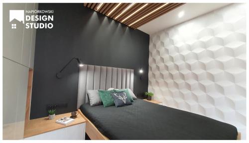a bedroom with a bed and a black and white wall at APARTAMENT ODRODZENIA 14 in Szczytno