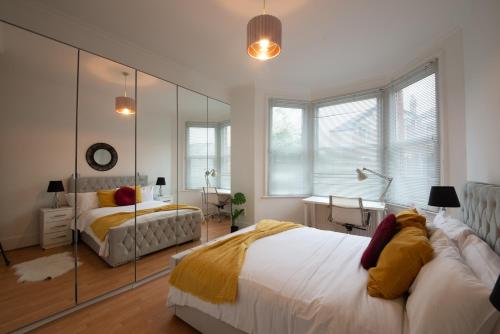 a bedroom with two beds and a mirror at Modern Spacious Holiday Home 75 in London