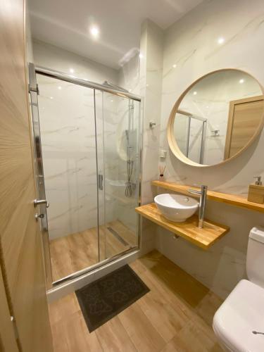 a bathroom with a shower and a sink and a mirror at Flight Apartments Airport by Airstay in Spata