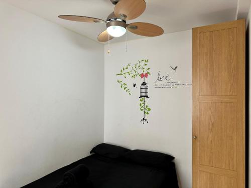 1 dormitorio con ventilador de techo y pared con un mural de flores en Apartamento en Santiago Bernabéu, en Madrid