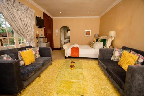 a living room with two couches and a couch at TDM's Boutique Guest House in Pretoria