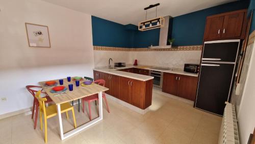 een keuken met een tafel met stoelen en een koelkast bij El Callejón in Vara de Rey