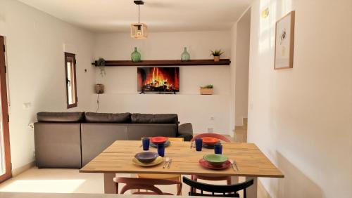 een woonkamer met een tafel en een open haard bij El Callejón in Vara de Rey