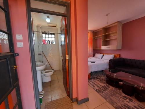 Kikuyu的住宿－Pine Residency w Secure Parking, Wifi, Netflix & Rooftop Views，客房设有带一张床的卧室和一间浴室。
