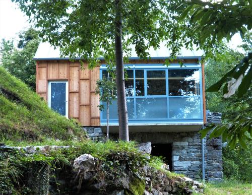 a house with a large window on a hill at Maison 4 petite Casa design nel parco naturale in Crodo
