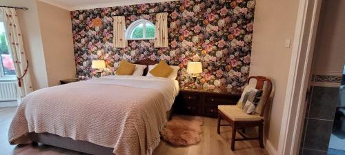 1 dormitorio con 1 cama y papel pintado con motivos florales en The Yoke, en Ballybrittas