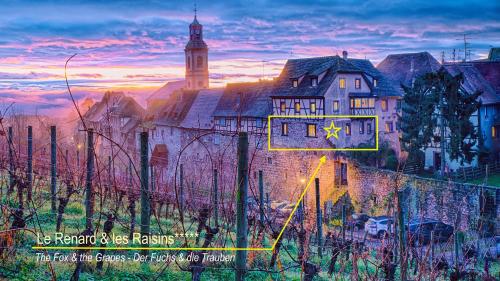 a building with a clock on the side of it at Remparts de Riquewihr - Le Renard & les Raisins in Riquewihr