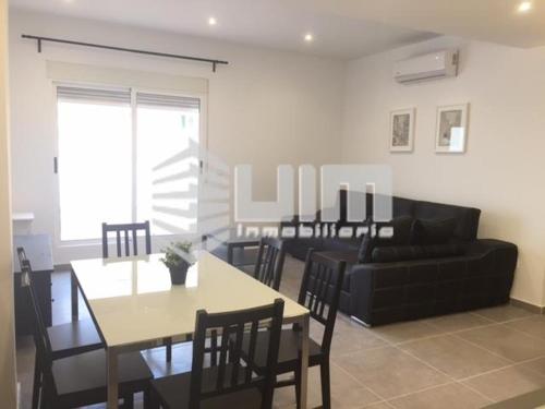 a living room with a black couch and a table at UIM Mediterraneo ATICO Hispanidad 3 Wifi in Puerto de Sagunto