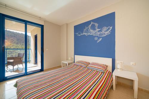sypialnia z łóżkiem i dużym oknem w obiekcie Beach and Green w Alicante