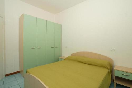 アルバ・アドリアティカにあるAppartamenti Alba Adriatica Viale Mazziniのベッドルーム(緑のベッド1台、キャビネット付)
