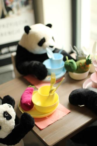 two stuffed pandas sitting at a table with plates and forks at Arboretum Hotel in Wolbórz