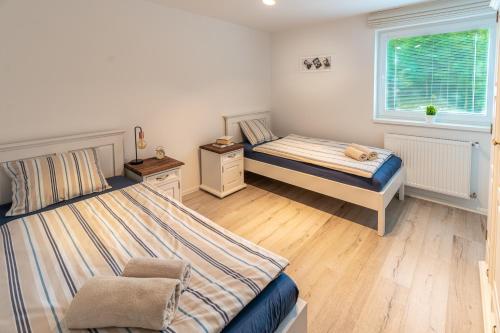 a bedroom with two beds and a chair in it at Chalet Ester - Luxury Provençal House in Orava in Námestovo