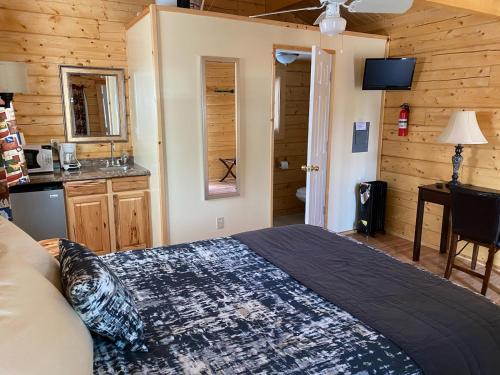 a bedroom with a bed and a kitchen in a cabin at Tok RV Village and Cabins in Tok