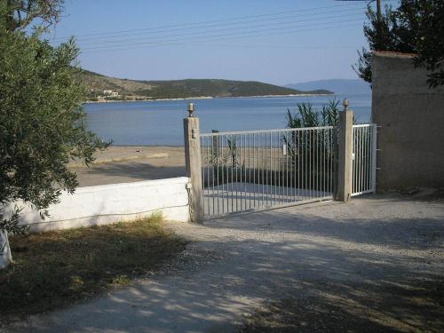 a gate in front of a beach with a body of water at Agnanti Studios in Amaliápoli