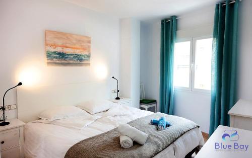 ein weißes Schlafzimmer mit einem Bett mit Handtüchern darauf in der Unterkunft Marianne's View in La Herradura