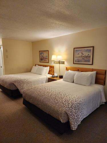 a hotel room with two beds and two lamps at Grantsburg Inn in Grantsburg