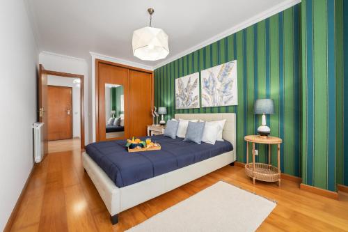 - une chambre avec un lit bleu et des murs verts dans l'établissement Ocean Getaway, à Nazaré