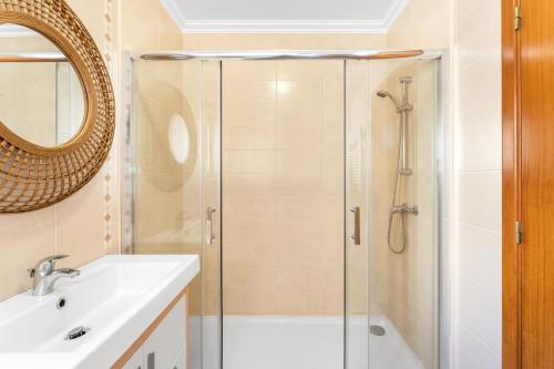 La salle de bains est pourvue d'une douche et d'un lavabo. dans l'établissement Ocean Getaway, à Nazaré