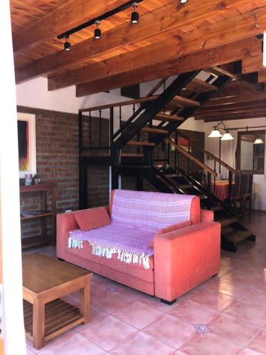 a living room with a red couch and a loft at Dos Pajaros in Villa Pehuenia