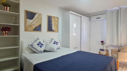 1 dormitorio con 1 cama con almohadas azules y blancas en Ilha do Caribe, en João Pessoa