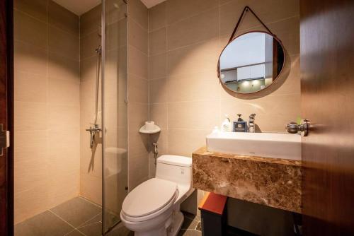 een badkamer met een toilet, een wastafel en een spiegel bij Masteri Millennium-Bitexco view-Ivyhouse in Ho Chi Minh-stad