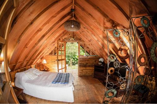a bedroom with a bed in a wooden room at Finca Colibrí Zafiro, Altos del Rosario in Cali