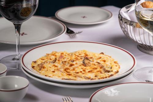 a table with a plate of food and a glass of wine at Sublime Lisboa in Lisbon