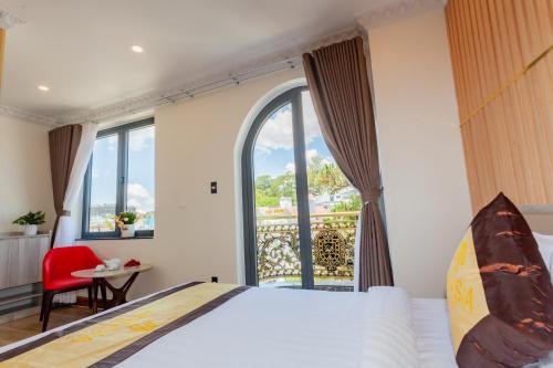 a bedroom with a bed and a large window at Anasia Hotel in Da Lat