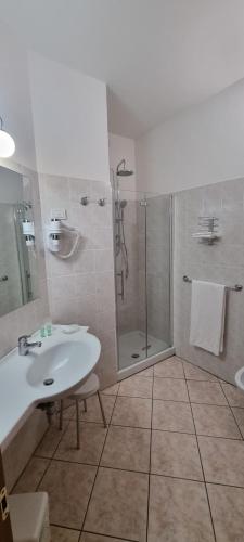 y baño con lavabo y ducha. en Hotel La Piccola Stazione en Torrita di Siena