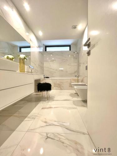 a white bathroom with a tub and a sink at Casa do Golfe by VinteOito in Amarante