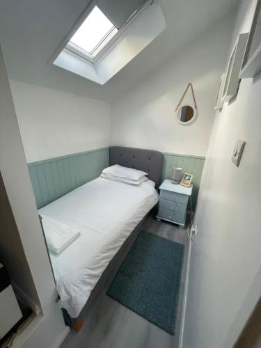 ヘイルにある20 Strawberry Hill cosy cottage sleeps 5の小さなベッドルーム(ベッド1台、窓付)