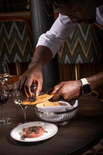 a person preparing a plate of food on a table at Sublime Lisboa in Lisbon