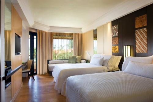 a hotel room with two beds and a television at The Westin Resort Nusa Dua, Bali in Nusa Dua