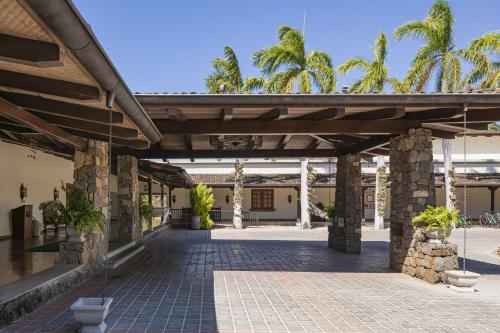 an outdoor patio with awning and palm trees at JW Marriott Guanacaste Resort & Spa in Tamarindo