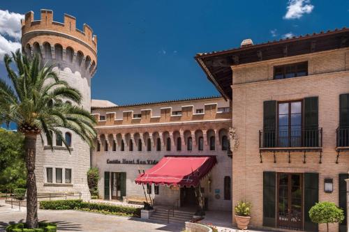 ein Gebäude mit einem Uhrturm und einer Palme in der Unterkunft Castillo Hotel Son Vida, a Luxury Collection Hotel, Mallorca - Adults Only in Palma de Mallorca