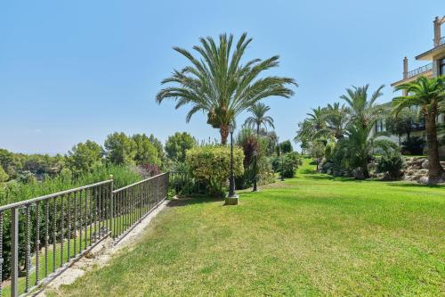 a park with palm trees and a fence at Castillo Hotel Son Vida, a Luxury Collection Hotel, Mallorca in Palma de Mallorca