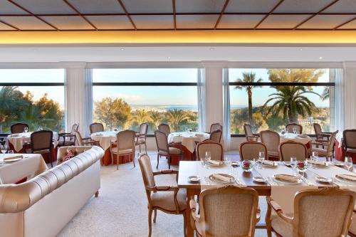 a restaurant with tables and chairs and large windows at Castillo Hotel Son Vida, a Luxury Collection Hotel, Mallorca in Palma de Mallorca