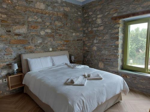 a bedroom with a large bed with towels on it at Villa Rokanes Glass Stone with Pool in Kouvéllai