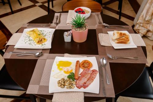 a table with plates of breakfast food on it at TDM's Boutique Guest House in Pretoria