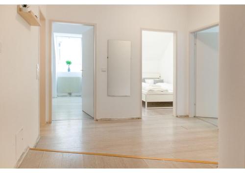 Habitación blanca vacía con espejo y cama en Homely 3BR Apt.- Perfect for families and groups en Viena